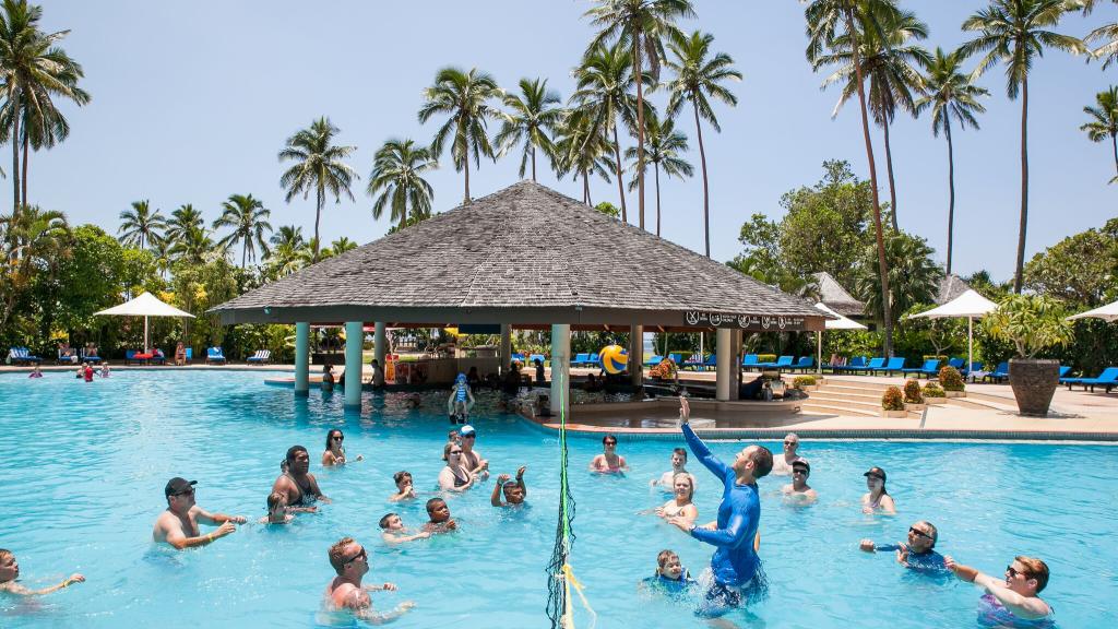Image of locals and tourists playing pool volleyball in resort